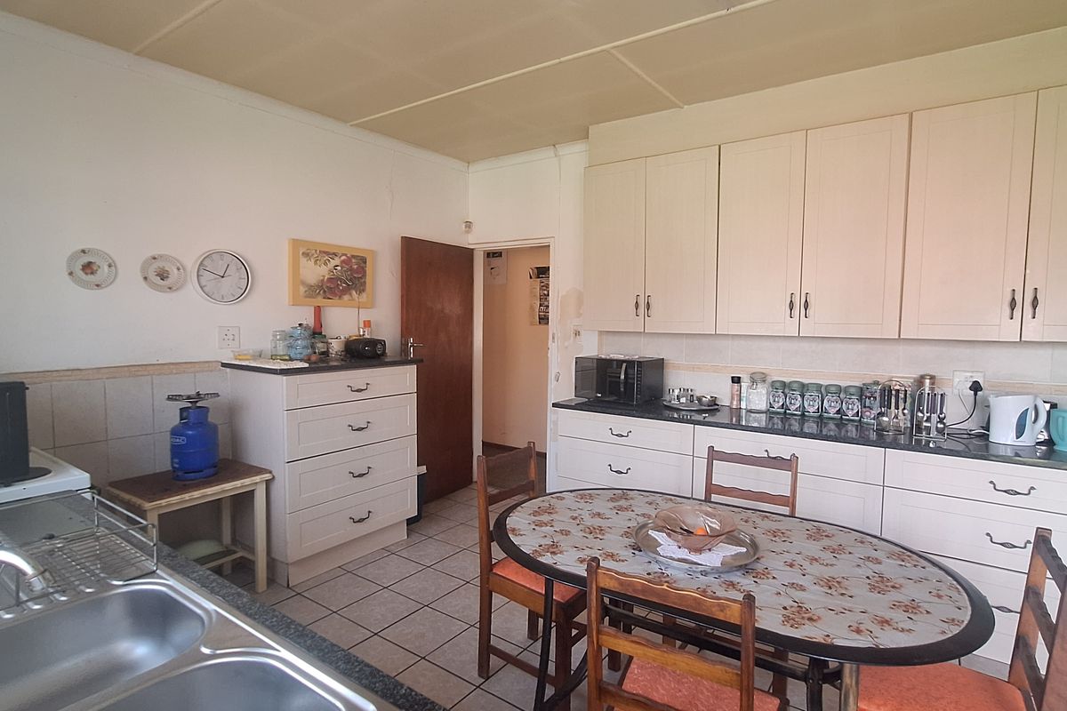 A functional kitchen featuring granite countertops, double bowl sink, and ample built-in cabinetry, with tiled flooring and a standard ceiling finish.
