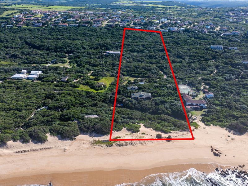 An aerial view of a large, expansive coastal property featuring extensive indigenous vegetation and direct access to the sandy beach.