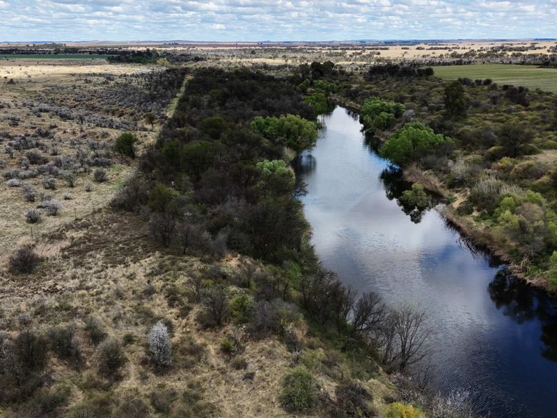 An aerial view of the farm property showcasing the natural river and surrounding landscape.