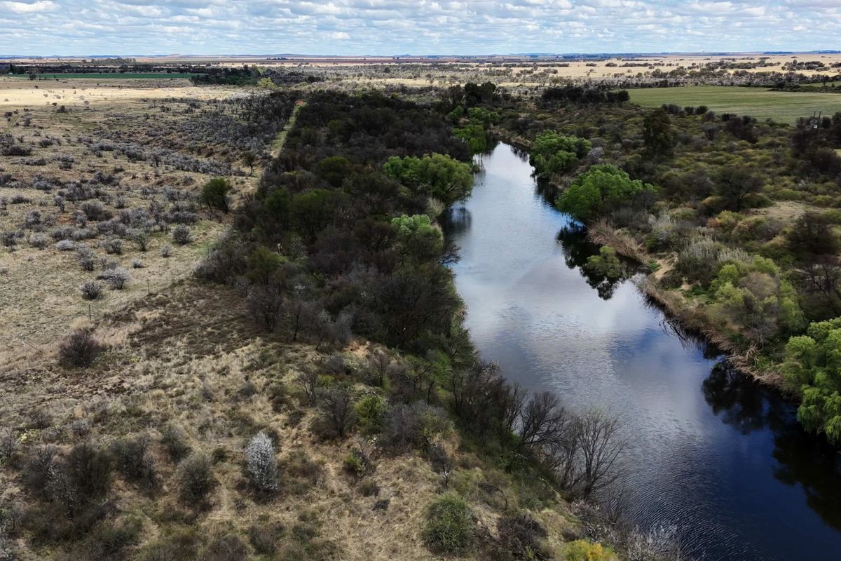 An aerial view of the farm property showcasing the natural river and surrounding landscape.