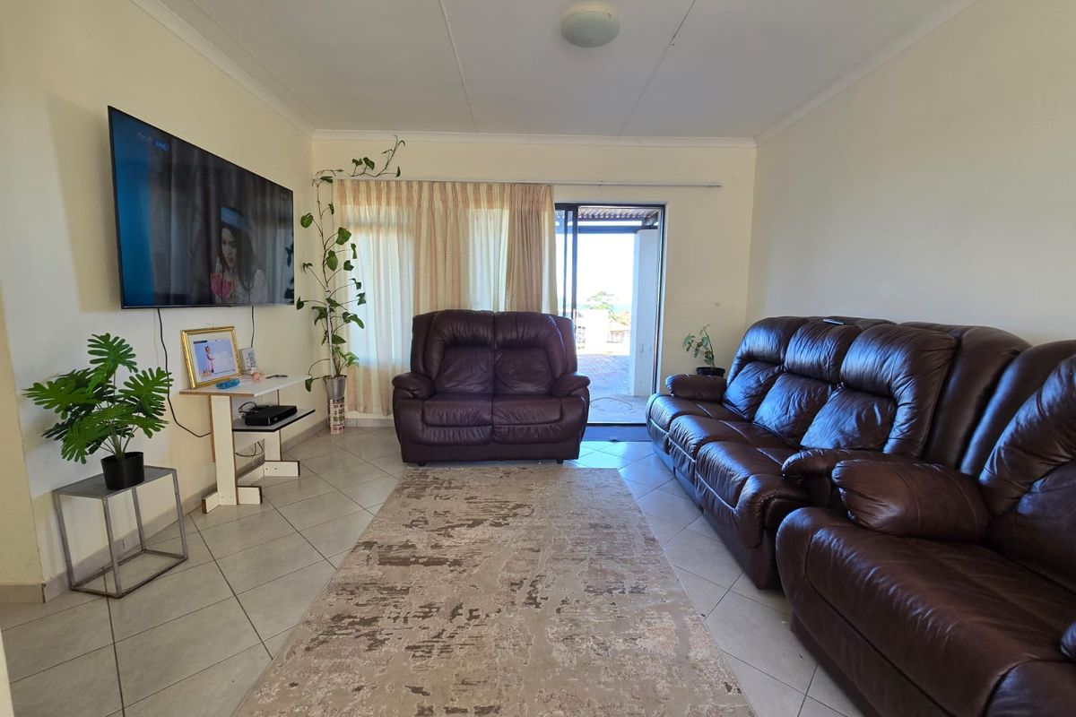 A functional living room featuring tiled flooring and a sliding glass door providing access to the outdoor area.