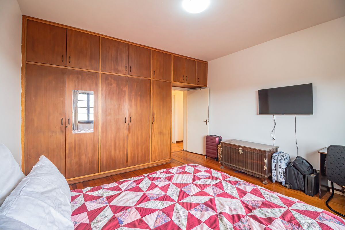 A bedroom featuring extensive floor-to-ceiling built-in wooden cabinetry and warm hardwood flooring.