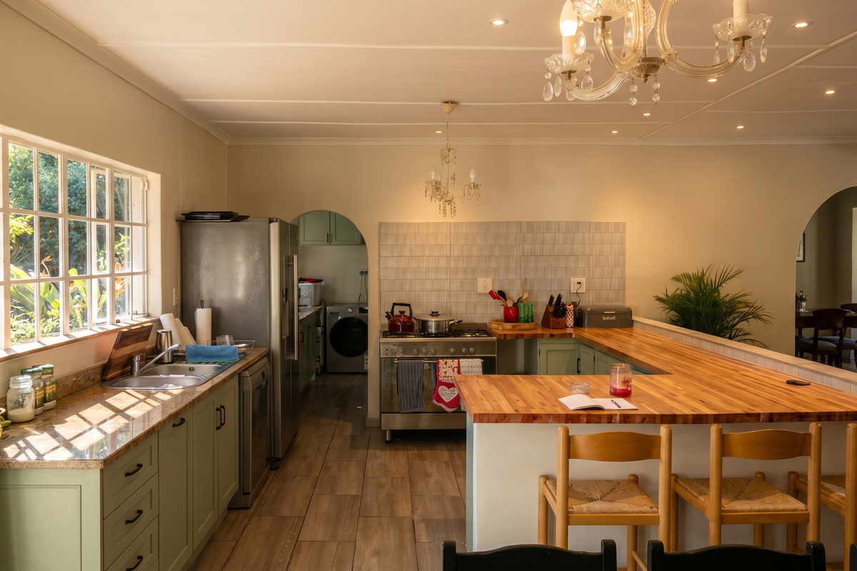 A well-lit kitchen featuring granite countertops, a large butcher block breakfast bar, gas stove, and elegant archways leading to adjacent living spaces.