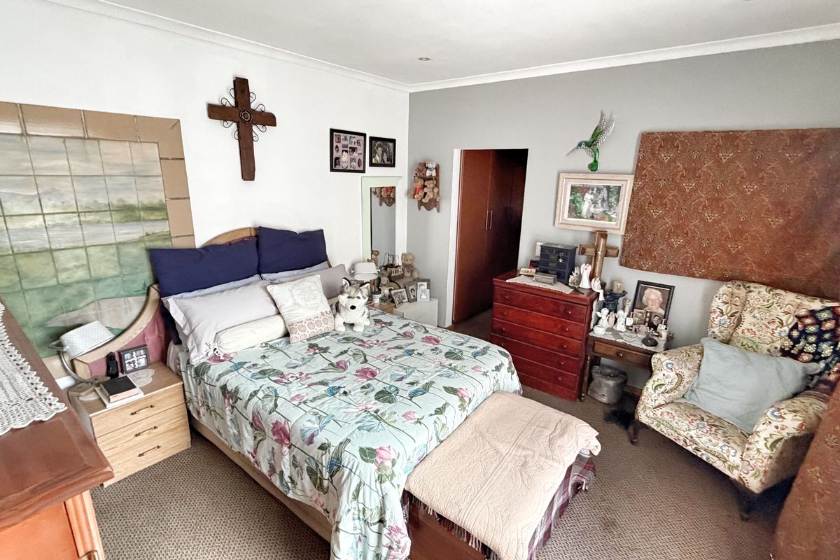 A carpeted bedroom featuring recessed ceiling lighting and a built-in cupboard, offering a functional and comfortable living space.
