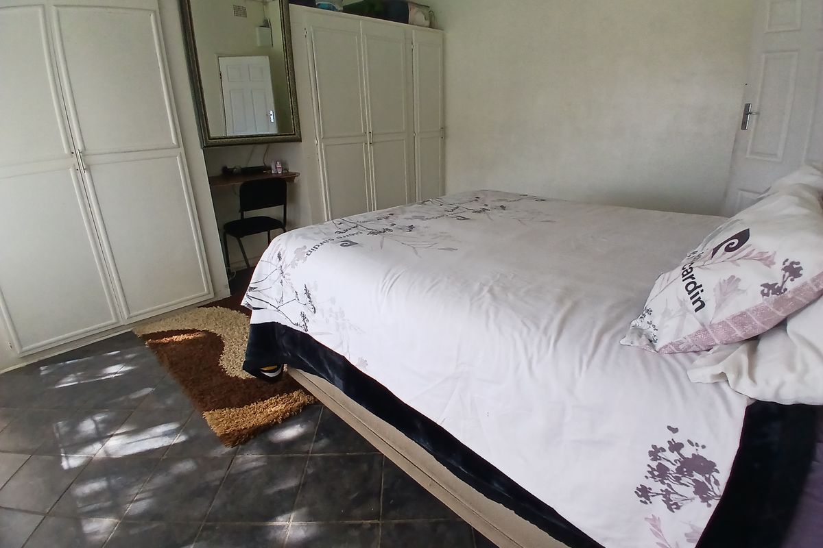 A bedroom featuring built-in cupboards and tiled flooring.