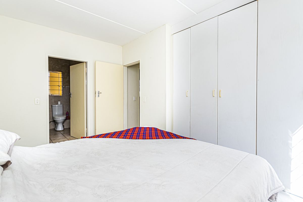 Bedroom featuring built-in cupboards and direct access to an en-suite bathroom.
