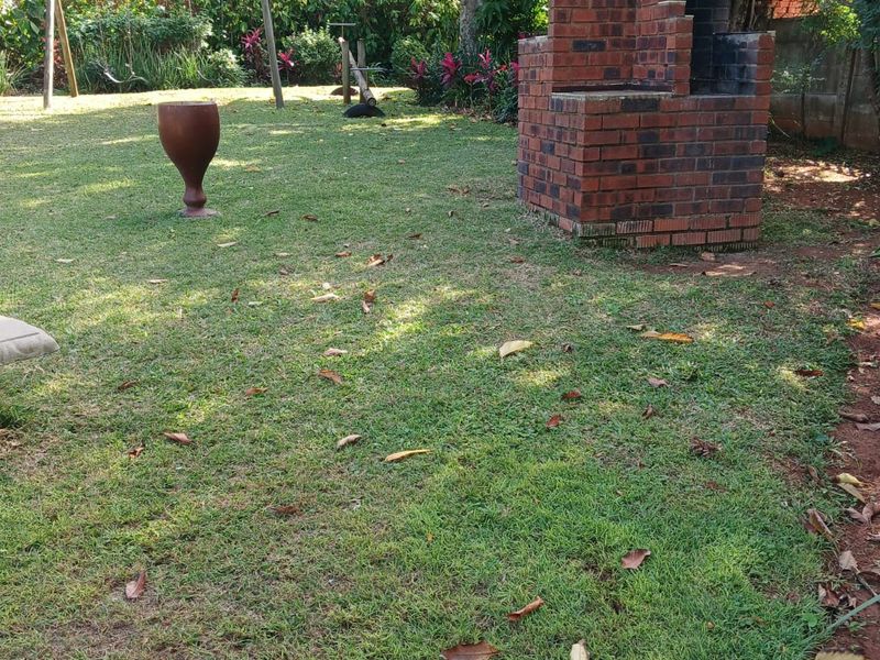 A private garden area featuring a built-in brick braai, established lawn, and perimeter fencing, offering potential for outdoor entertainment.