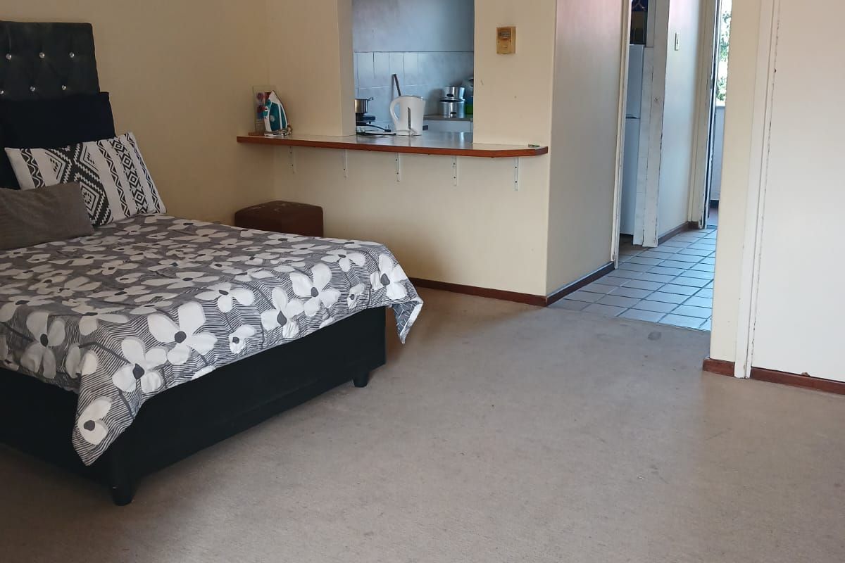 Bedroom featuring a ceiling fan, built-in storage, and a convenient serving hatch opening into the kitchen area.