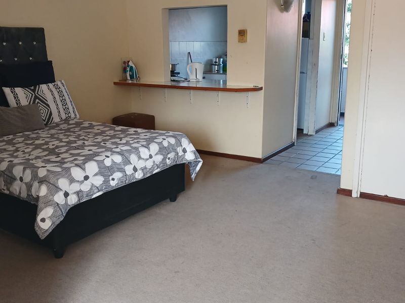 Bedroom featuring a ceiling fan, built-in storage, and a convenient serving hatch opening into the kitchen area.