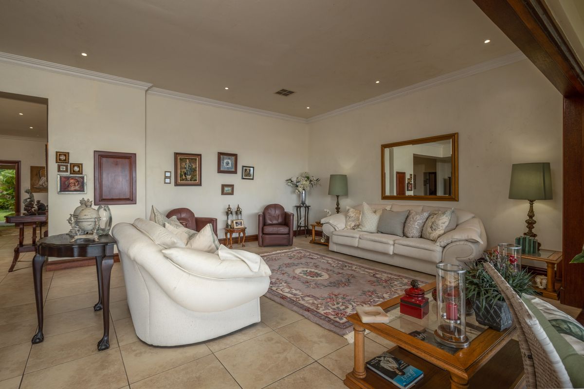 Spacious living room featuring tiled flooring, recessed downlighting, and crown molding, offering a comfortable and well-lit area for relaxation.
