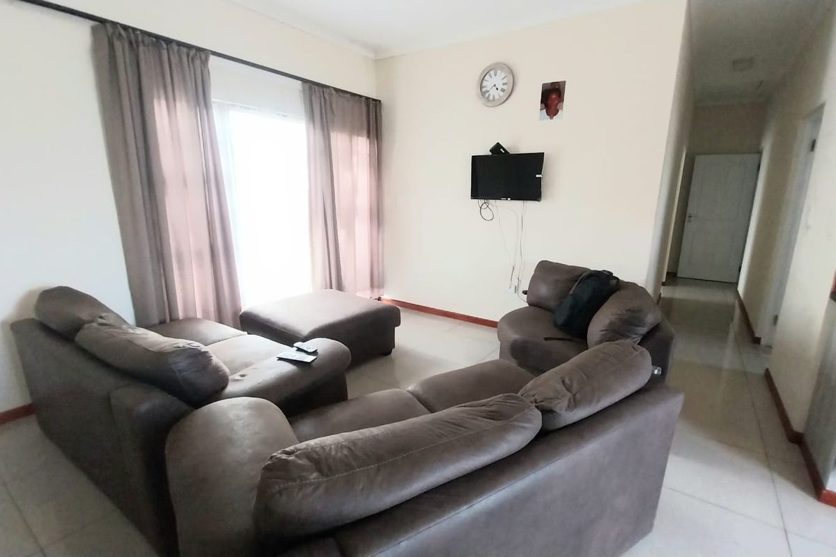 A living room featuring tiled flooring and a sliding glass door providing access to the exterior.