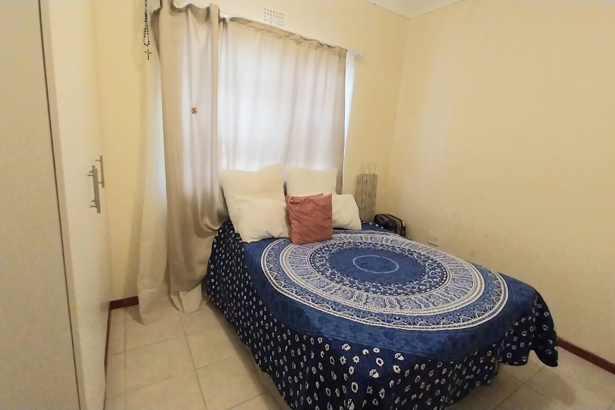 A functional bedroom featuring tiled flooring and a built-in wardrobe, providing essential storage space.