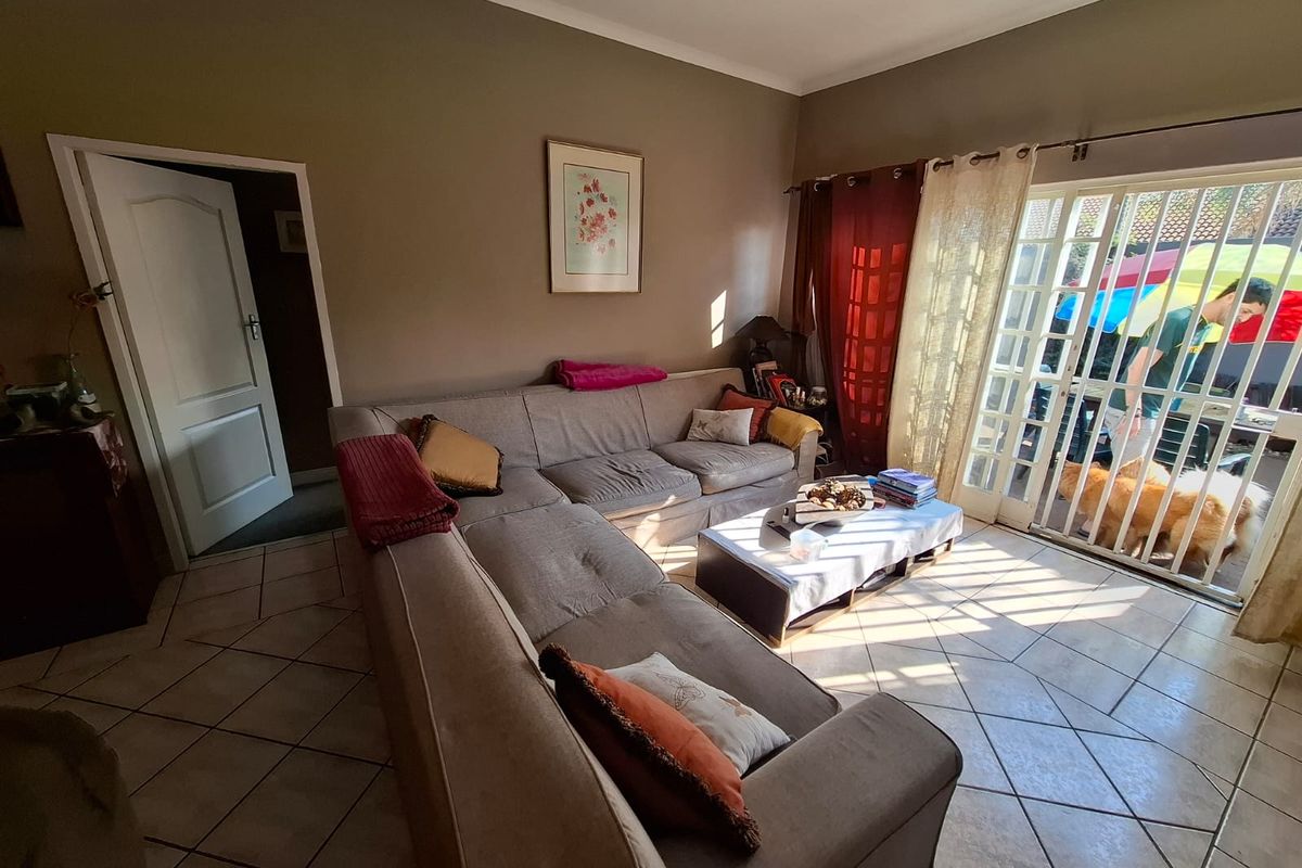 A living room featuring tiled flooring and large sliding glass doors that provide direct access to the outdoor patio area.