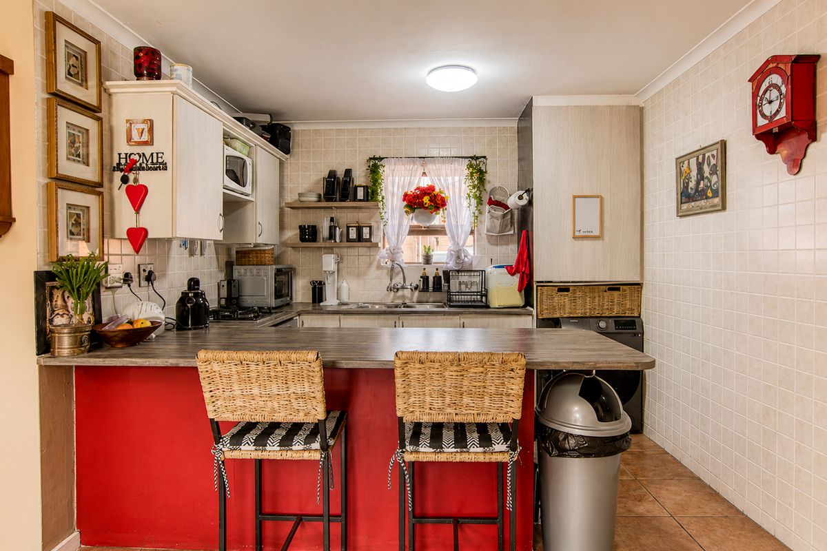 A functional kitchen featuring a breakfast bar, tiled backsplash, ample cabinetry, and integrated appliances, offering a practical layout for daily cooking and dining.