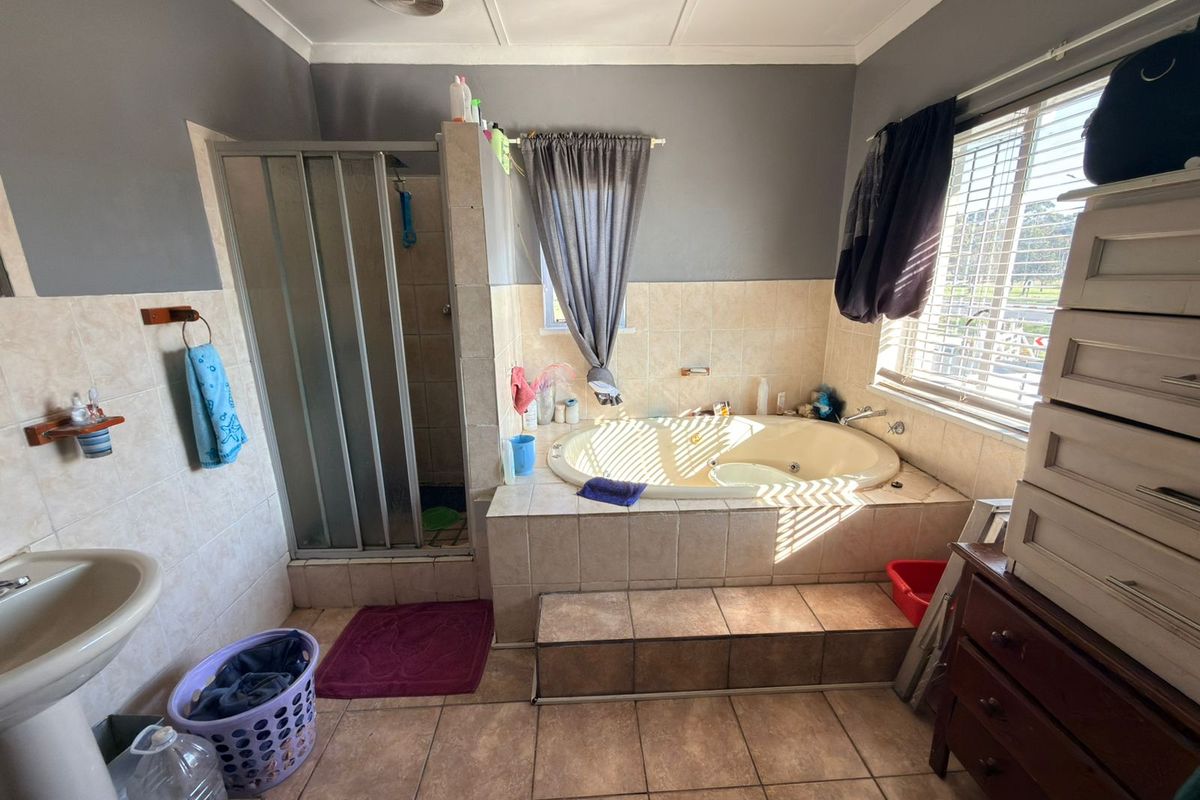 A dated bathroom featuring a built-in bathtub, separate shower enclosure, and pedestal basin with tiled finishes throughout.