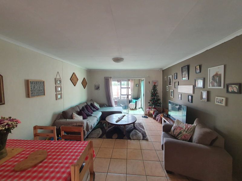 Open plan living and dining area featuring tiled flooring and a sliding glass door providing access to the patio.