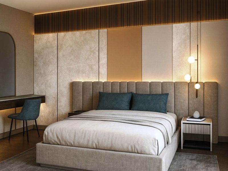 A modern, elegantly designed bedroom featuring custom upholstered headboard, integrated wall paneling, recessed accent lighting, and a sleek built-in vanity area.