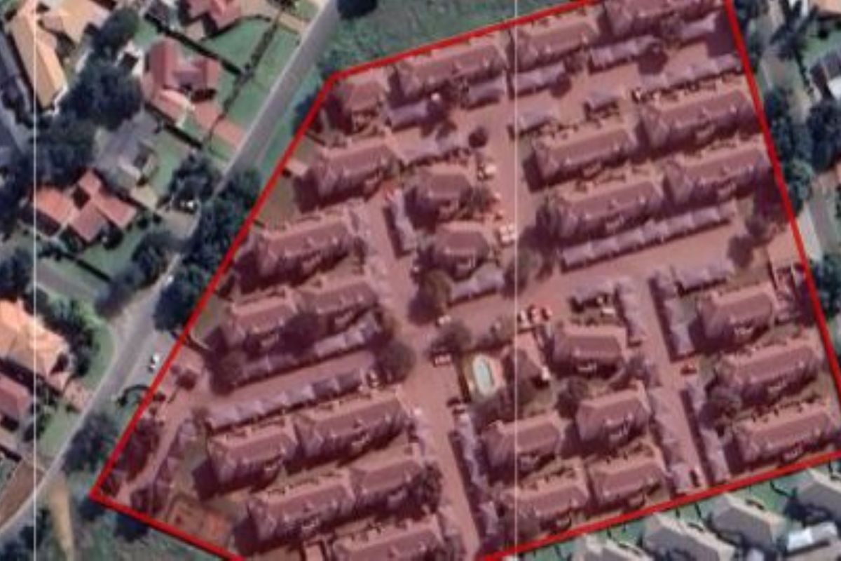 Aerial view of the townhouse complex showing the site layout, multiple residential units, internal road network, and communal swimming pool area.