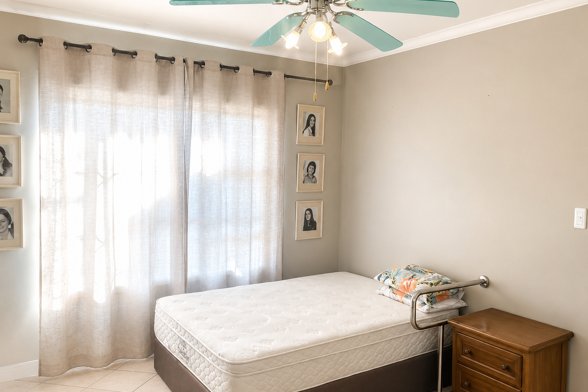 A well-maintained bedroom featuring neutral wall tones, tiled flooring, and a functional ceiling fan with integrated lighting.