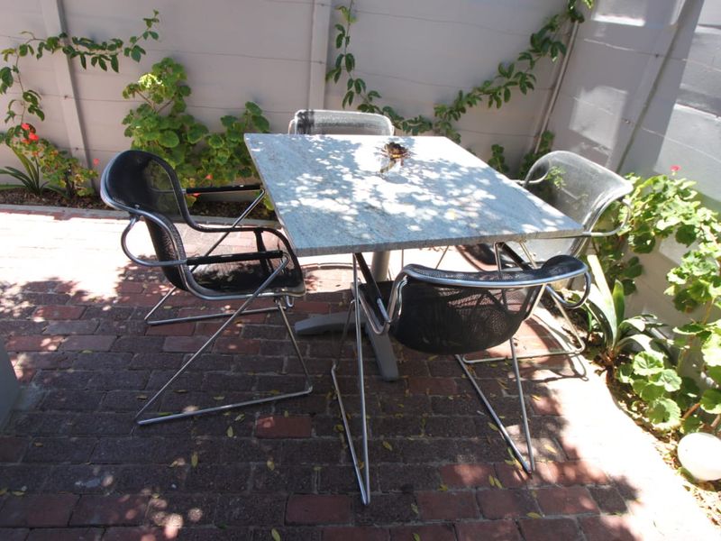 A private outdoor patio area featuring brick paving and a boundary wall, suitable for outdoor dining and relaxation.