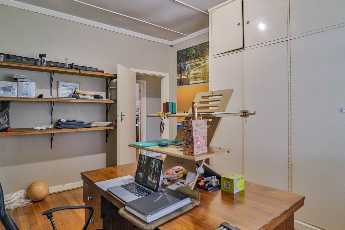A bedroom featuring timber flooring, wall-mounted shelving, and ample built-in cupboard storage space.