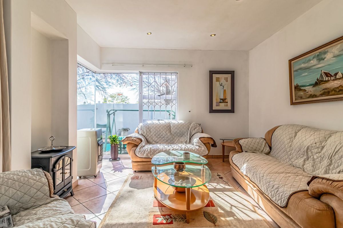 A bright living room featuring tiled flooring, recessed lighting, and a sliding glass door providing access to the outdoor area.