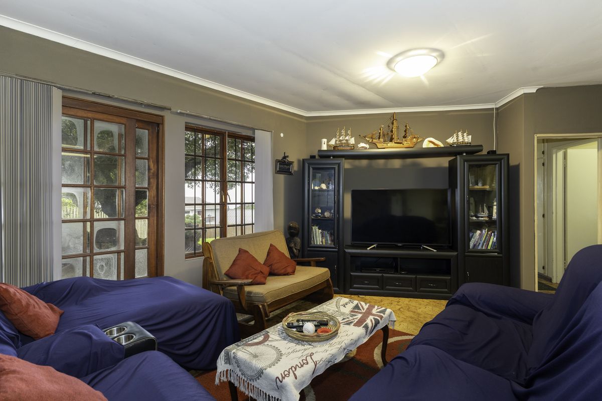 A living room featuring a sliding glass door, neutral wall tones, and cove cornicing, providing a functional space for relaxation.