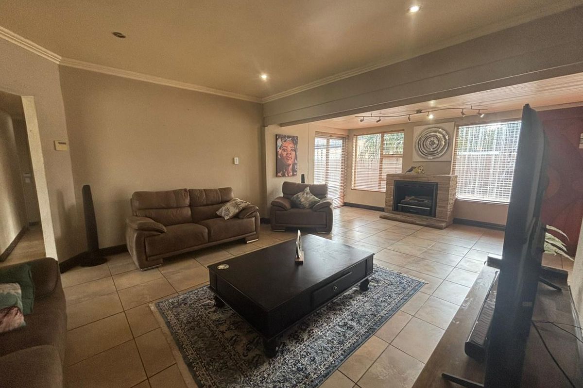Spacious living room featuring tiled flooring, a built-in fireplace, and recessed lighting, offering a comfortable and functional layout.