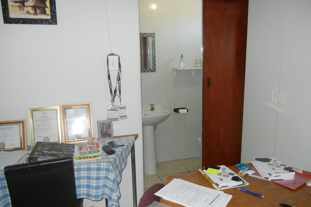 A bedroom featuring a built-in wardrobe and an en-suite bathroom with a pedestal basin, accessible via a sliding door.