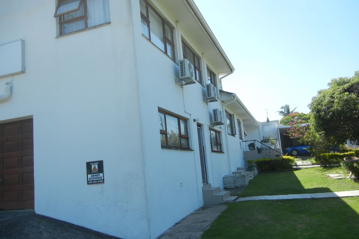 Side and rear view of the two-story house featuring exterior air conditioning units, a garage, and a maintained lawn area.