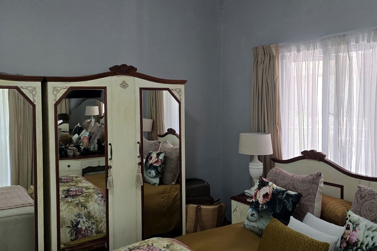 A spacious bedroom featuring neutral wall tones and a large window that allows for ample natural light.