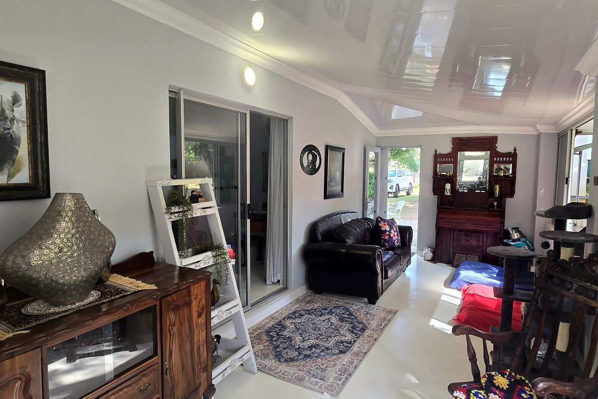 A bright living area featuring a glossy ceiling, recessed lighting, and large sliding glass doors that provide ample natural light and garden access.