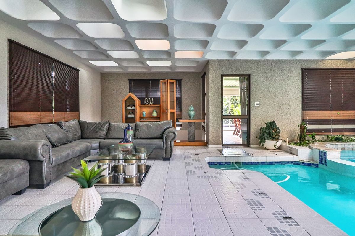Unique living area featuring a distinctive waffle slab ceiling and an integrated indoor swimming pool with tiled surround.