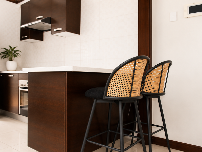 Modern kitchen featuring dark wood cabinetry, stone countertops, built-in oven, and an integrated extractor fan with a clean tiled backsplash.