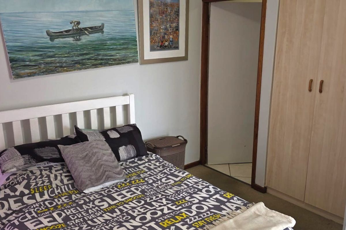A functional bedroom featuring a built-in wardrobe and neutral wall finishes, providing a comfortable and practical sleeping space.