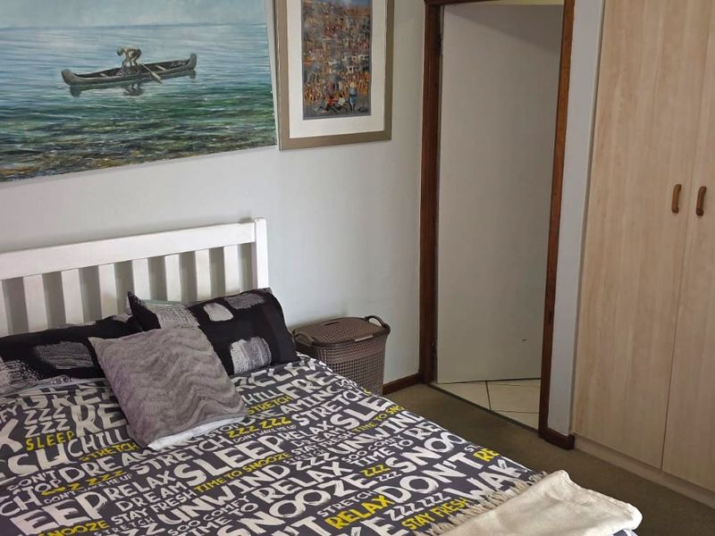 A functional bedroom featuring a built-in wardrobe and neutral wall finishes, providing a comfortable and practical sleeping space.