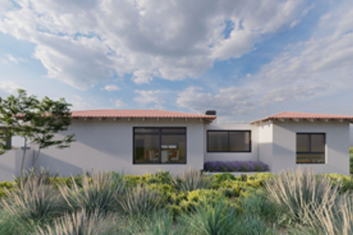 A rear view of a modern single-story residence featuring terracotta roof tiles, clean plastered walls, and large aluminium-framed windows overlooking a landscaped garden.