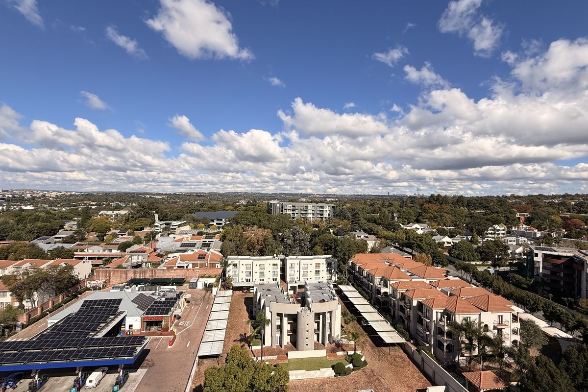An elevated aerial view showcasing the surrounding residential neighborhood, local infrastructure, and urban landscape from the penthouse perspective.