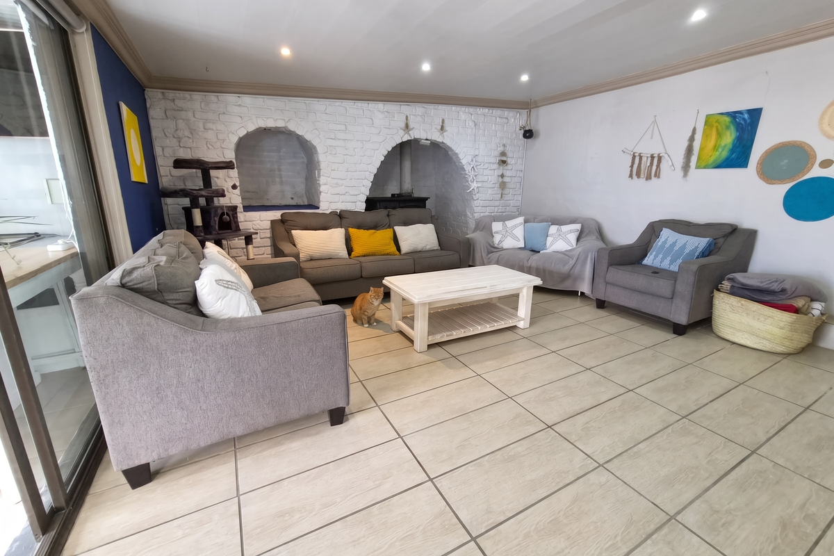 Spacious living room featuring unique exposed brick archways, neutral tiled flooring, and large sliding glass doors providing ample natural light.
