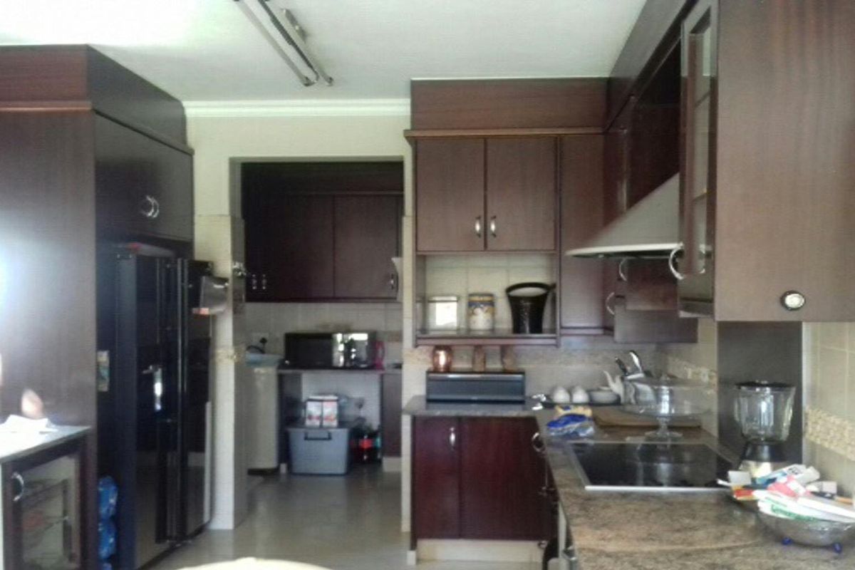 A functional kitchen featuring dark wood cabinetry, granite countertops, and integrated appliances, offering ample storage and workspace.