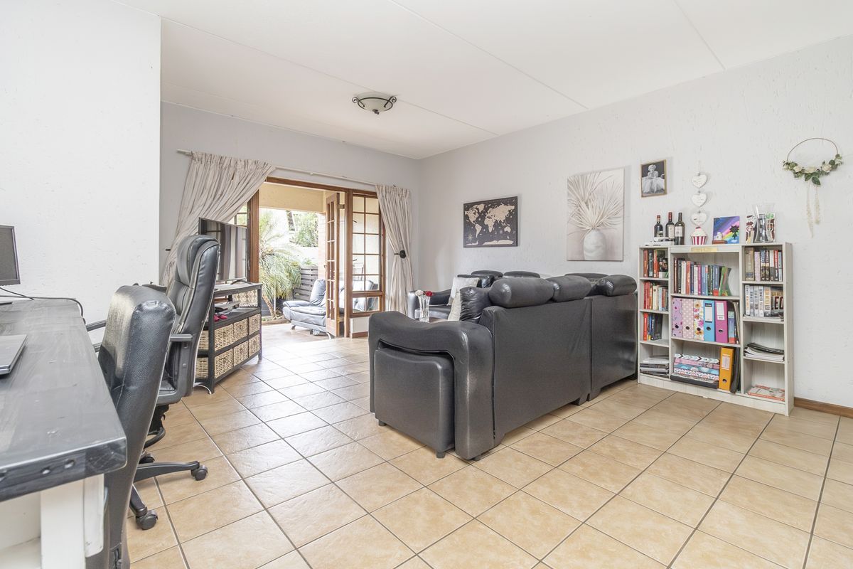 A living room featuring tiled flooring and sliding glass doors that provide access to an outdoor patio area.