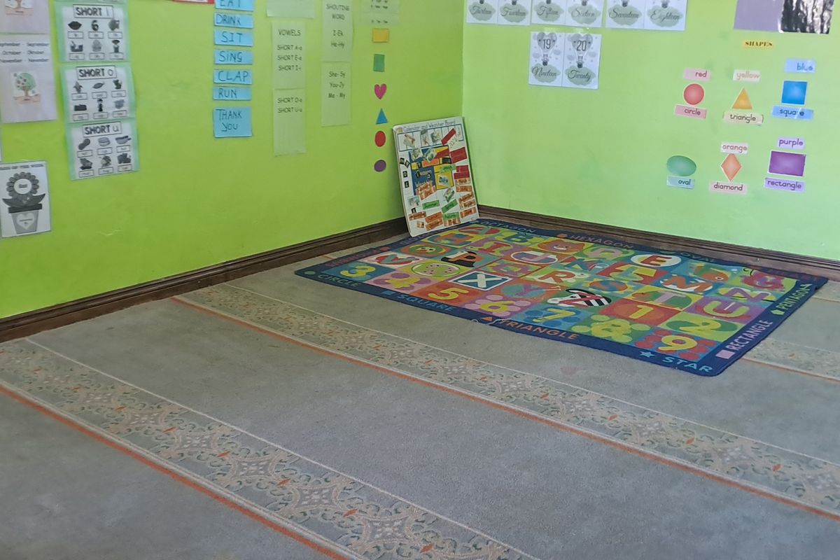 A room currently utilized as a learning space, featuring green painted walls and fitted carpeting, suitable for conversion into a bedroom or study.