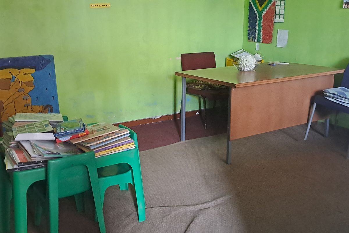 A multi-purpose room featuring carpeted flooring and painted walls, currently utilized as a workspace or study area.