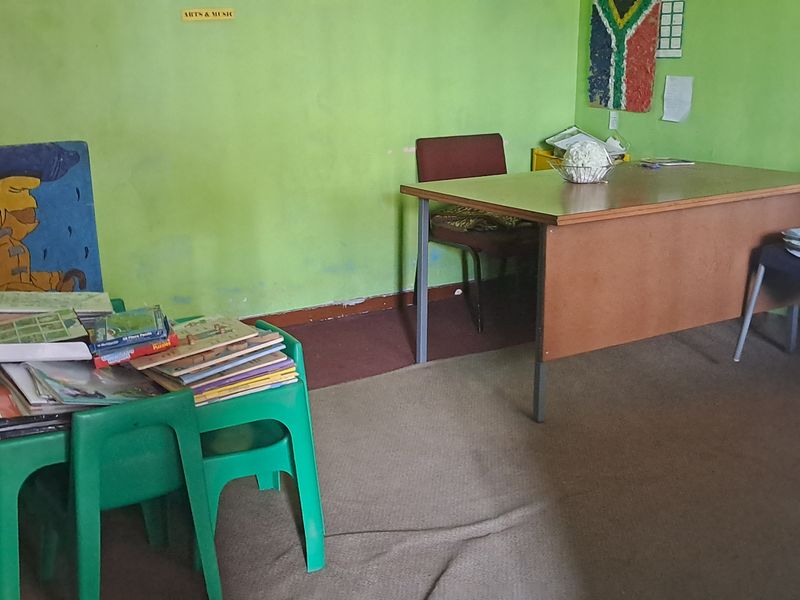 A multi-purpose room featuring carpeted flooring and painted walls, currently utilized as a workspace or study area.