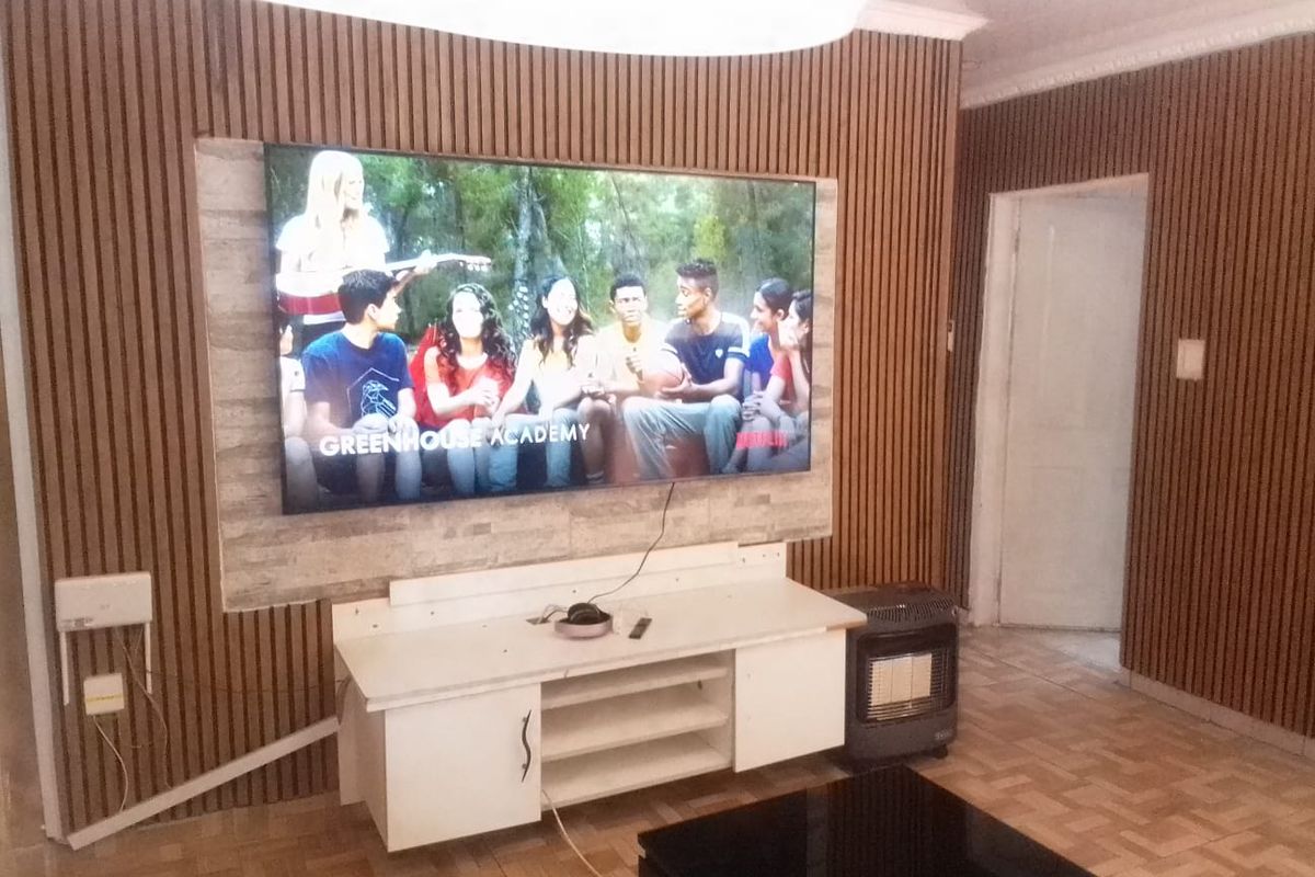 Living room featuring a modern slatted timber feature wall with stone veneer accent and parquet flooring.
