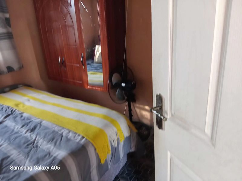 A bedroom featuring a built-in wooden wardrobe and standard door access.