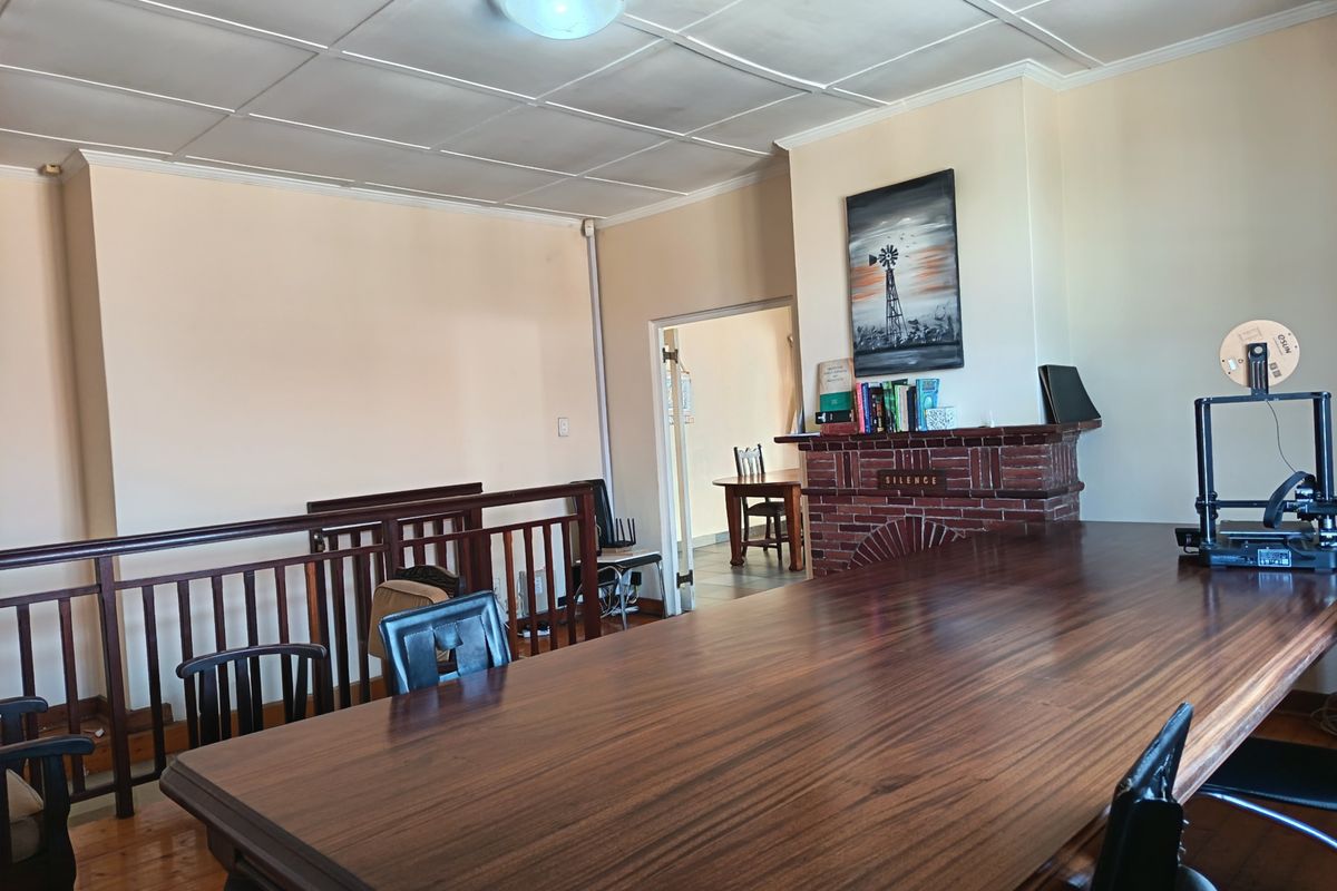 Spacious living area featuring a brick fireplace, timber flooring, and a wooden balustrade overlooking the lower level.