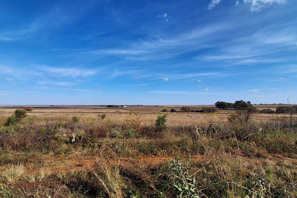 A wide-angle view of the expansive, undeveloped residential land featuring natural vegetation and open horizon.
