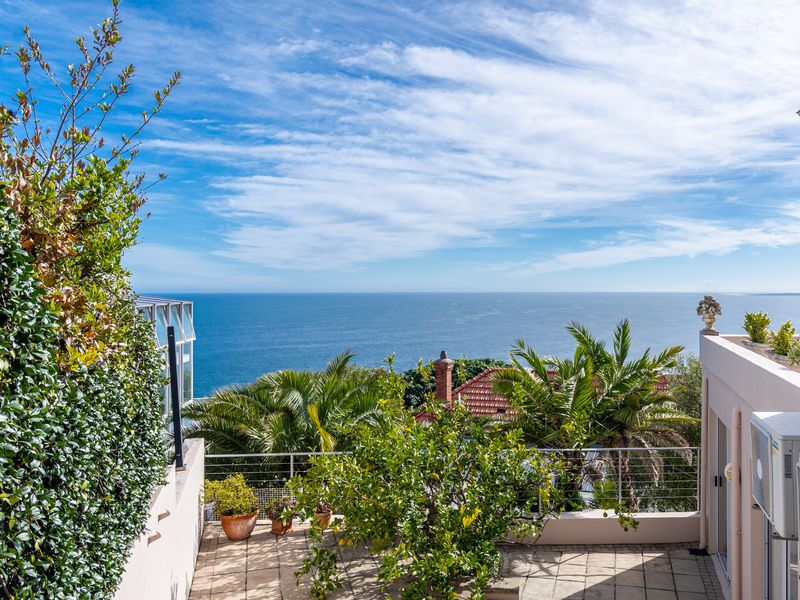 A spacious outdoor terrace featuring paved flooring, stainless steel railings, and expansive, unobstructed ocean views.