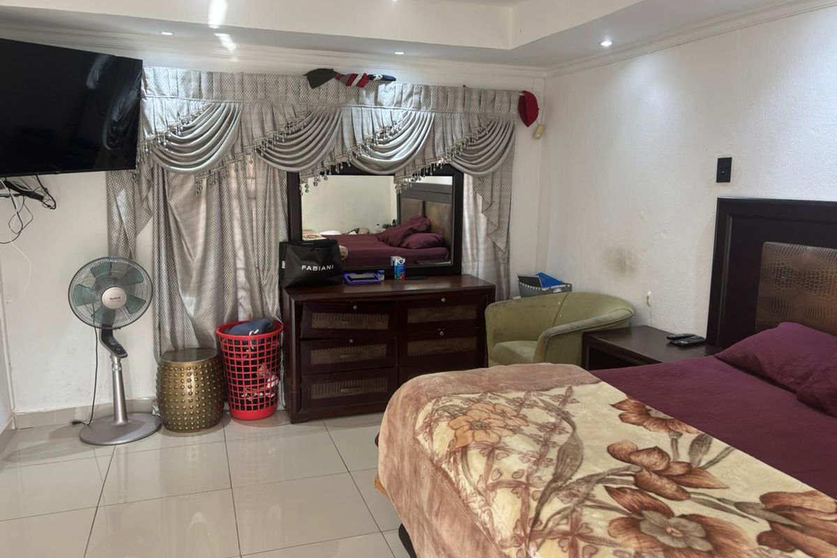 A bedroom featuring tiled flooring, recessed ceiling lighting, and decorative cove molding.